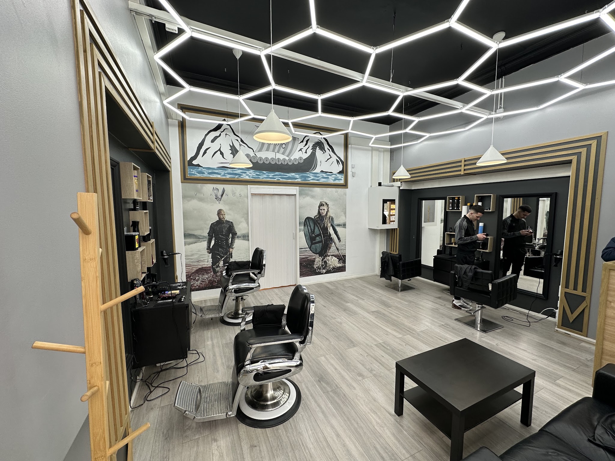 Barber chairs, mirrors and geometric ceiling lights inside the shop.